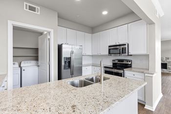 A kitchen with white cabinets and granite countertops